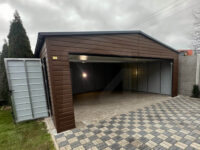 Garaż blaszany dwuspadowy 6 m x 5,8 m Orzech z bramą segmentową Grafit otwarta brama i drzwi boczne