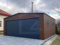 Garaż blaszany dwuspadowy 6 m x 5,8 m Orzech z bramą segmentową Grafit widok na ścianę z dwoma oknami